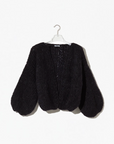 Black knitted cardigan on a hanger against a white background