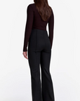 Person wearing a black outfit with wide-leg pants on a white background