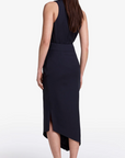 Woman wearing a black sleeveless dress with a slit on a white background