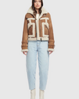 Woman wearing a brown shearling jacket with geometric patterns on a white background