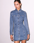 Woman wearing a denim dress against a white background