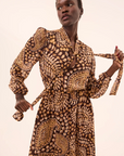 Woman wearing a patterned dress against a plain background