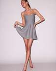 Woman wearing a gray dress on a plain background