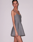 Woman wearing a gray dress against a plain background