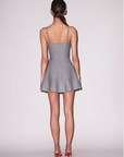 Woman wearing a gray dress with thin straps on a white background