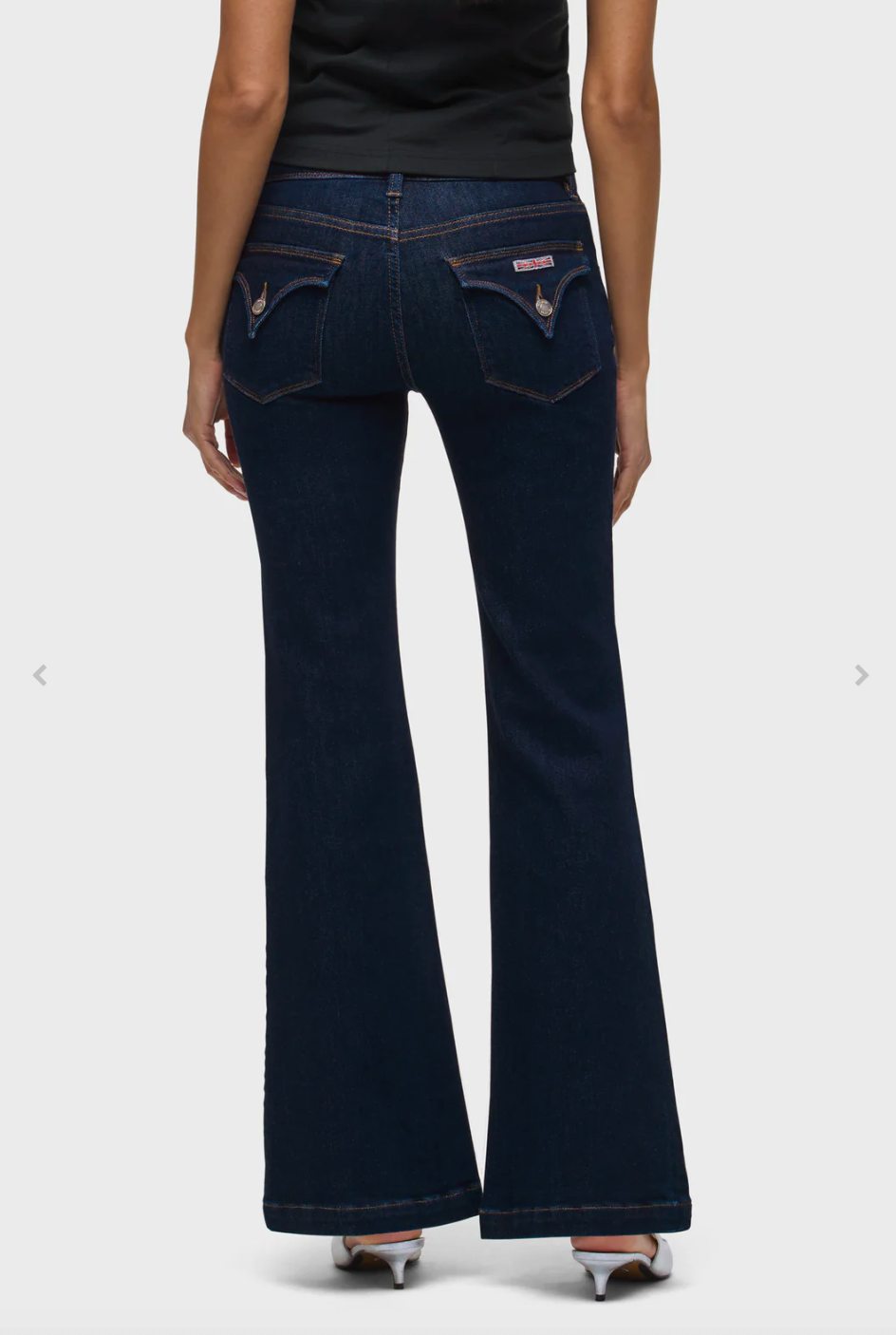 Dark blue jeans worn by a person on a white background