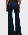 Dark blue jeans worn by a person on a white background