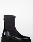 Black boot with a thick sole on a white background