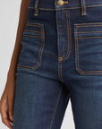 Close-up of dark blue jeans with a white background