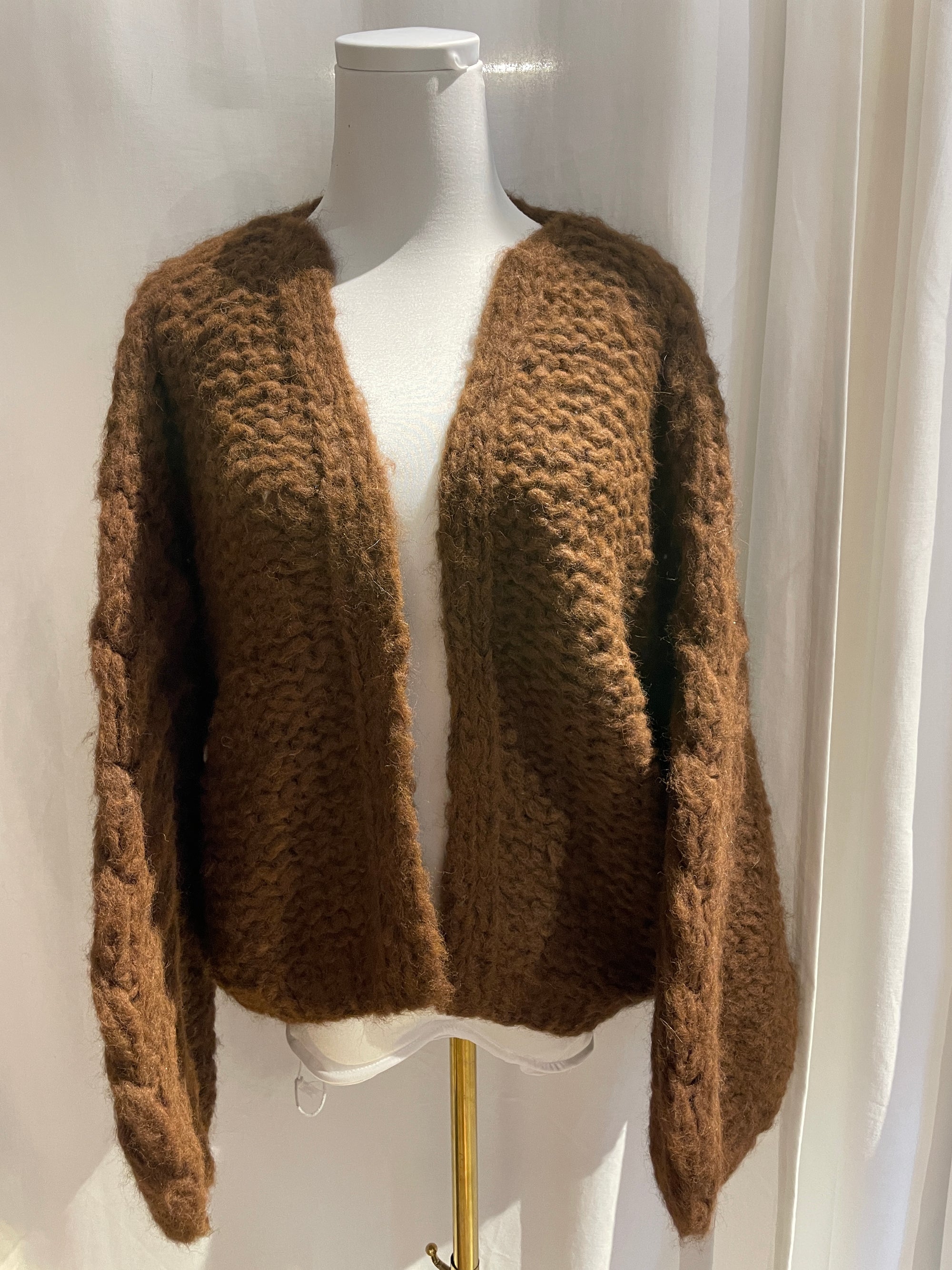 Brown knitted cardigan on a white mannequin with a white background