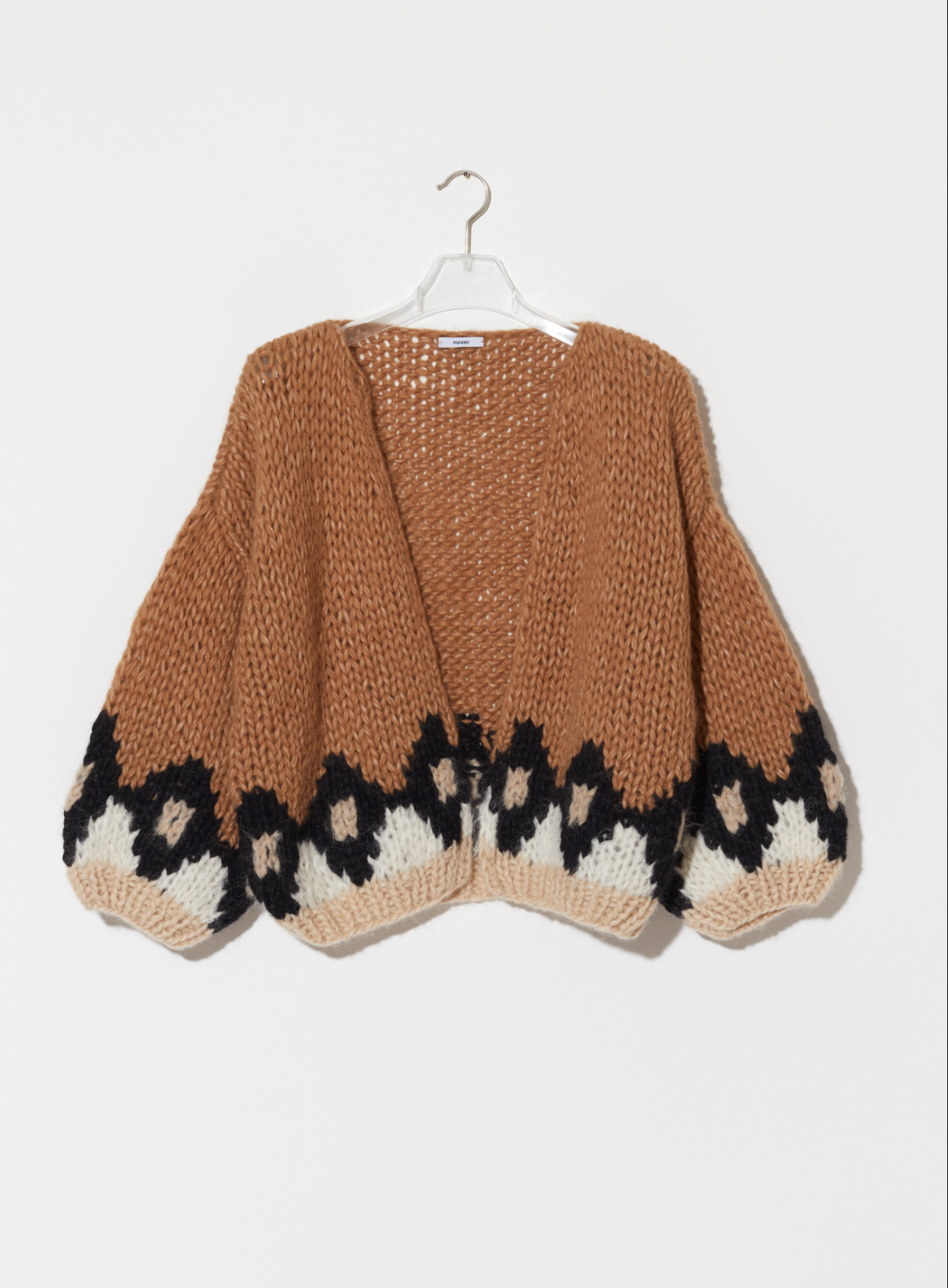 Brown knitted cardigan with black and white pattern on a hanger against a white background