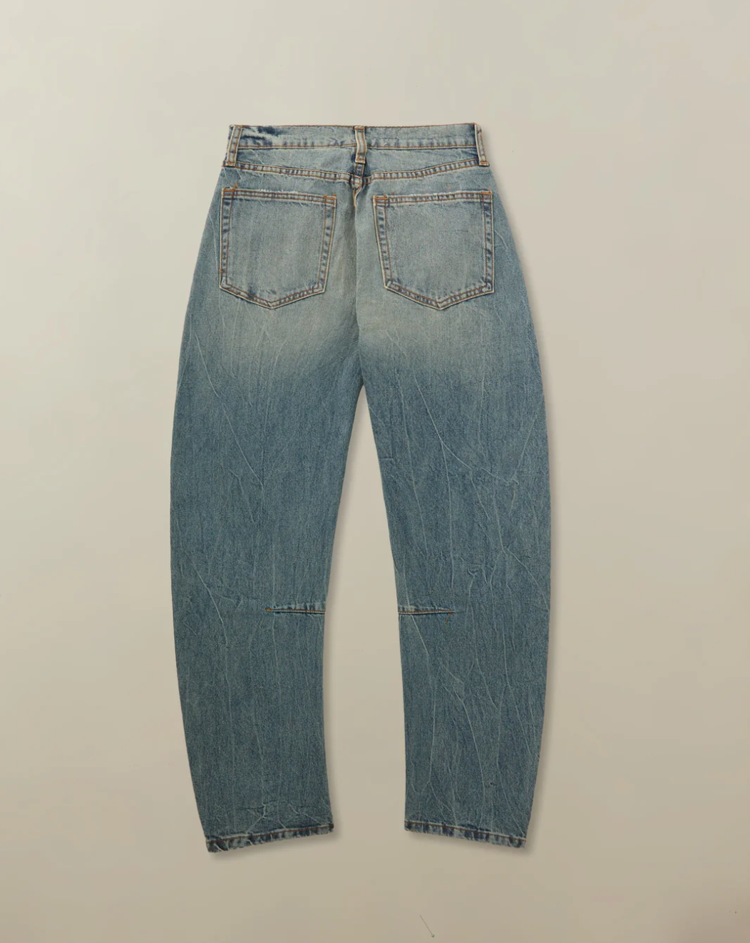 Pair of blue jeans on a beige background