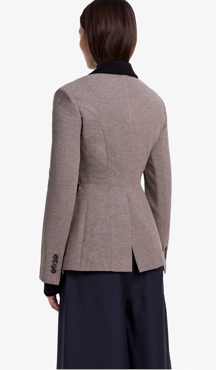 Brown blazer worn by a person on a white background