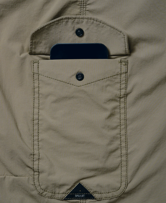 Close-up of a beige jacket pocket with a phone inside, featuring the Solognac brand logo.