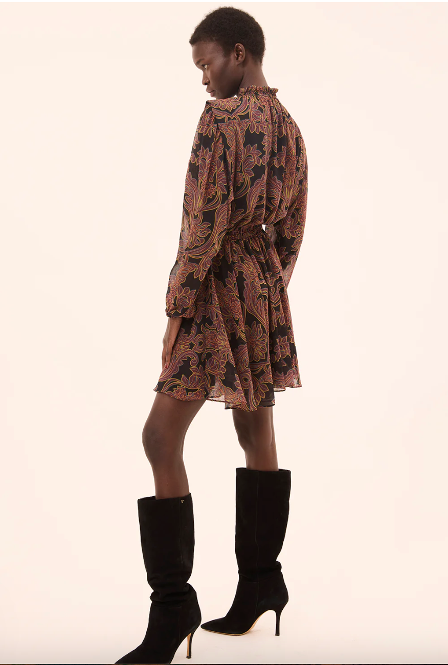 Woman wearing a patterned dress and black high-heeled boots on a white background