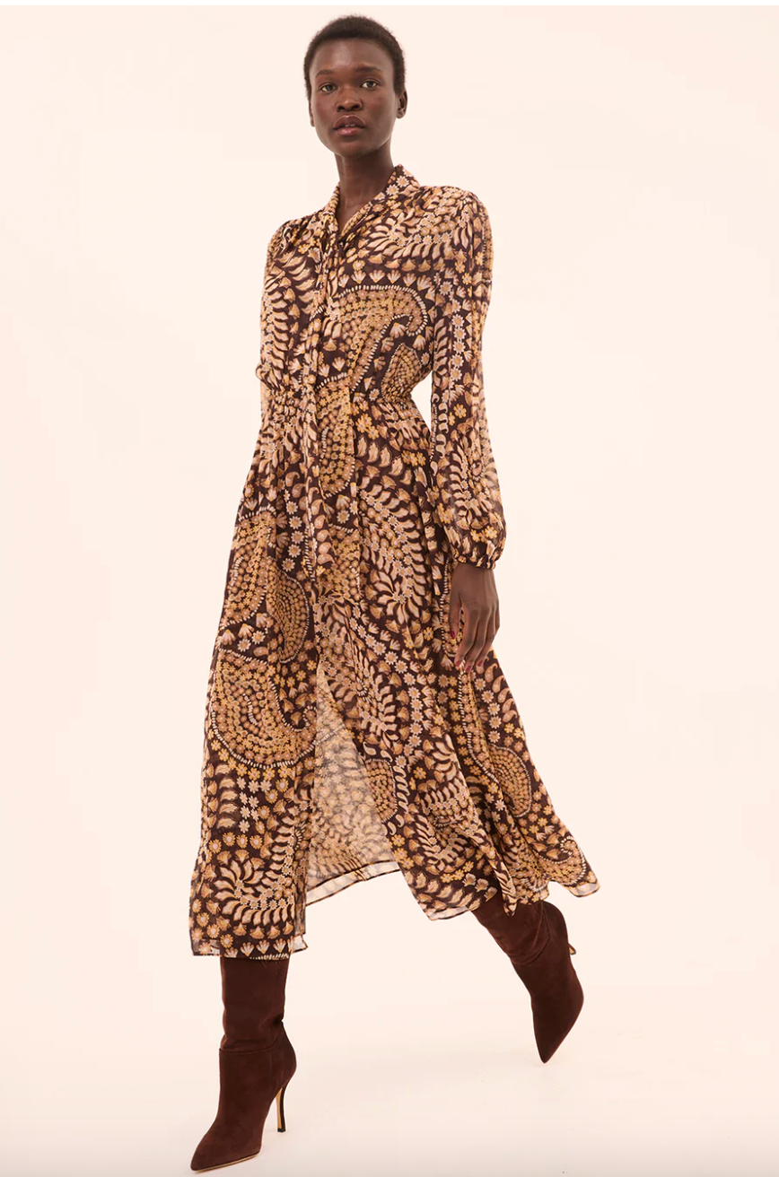 Woman wearing a patterned dress on a beige background