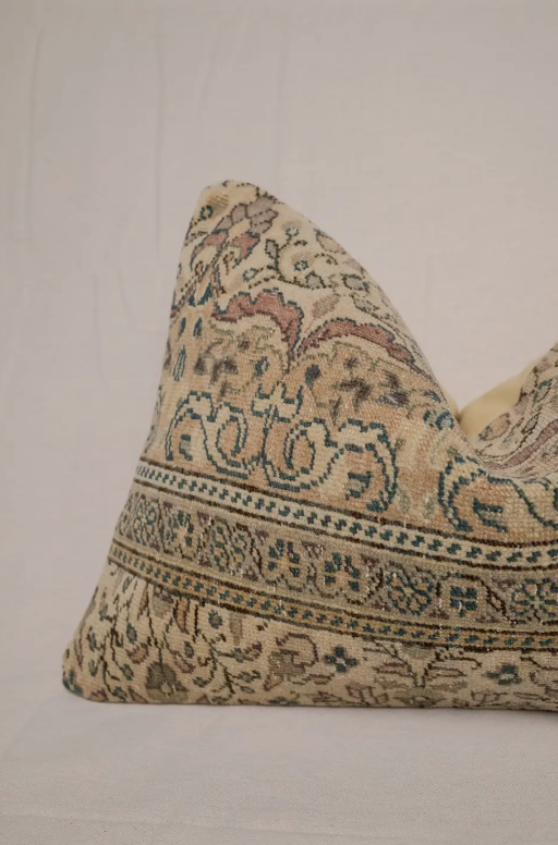 Decorative pillow with intricate paisley pattern on a plain background