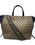 Brown woven handbag with a patterned strap on a white background