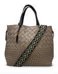 Beige woven handbag with a patterned strap on a white background
