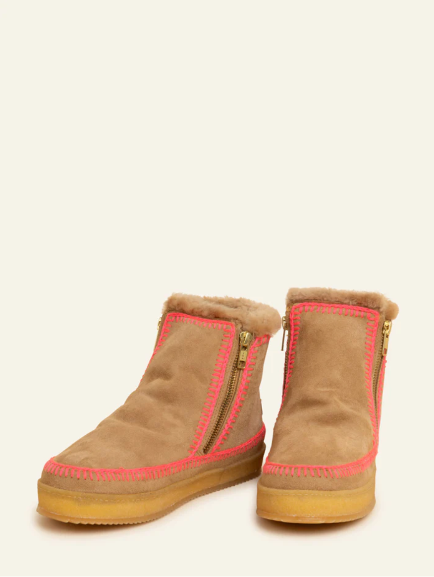 Pair of brown suede boots with pink interior lining on a white background