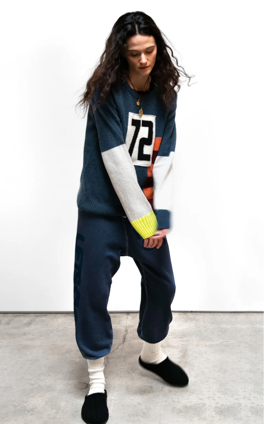 Person wearing a dark blue outfit with a number 72 on a white background