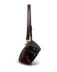 Brown leather bag with gold accents on a white background