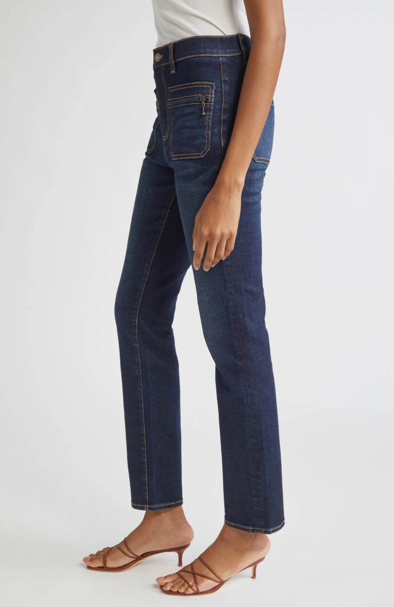 Person wearing dark blue jeans on a white background
