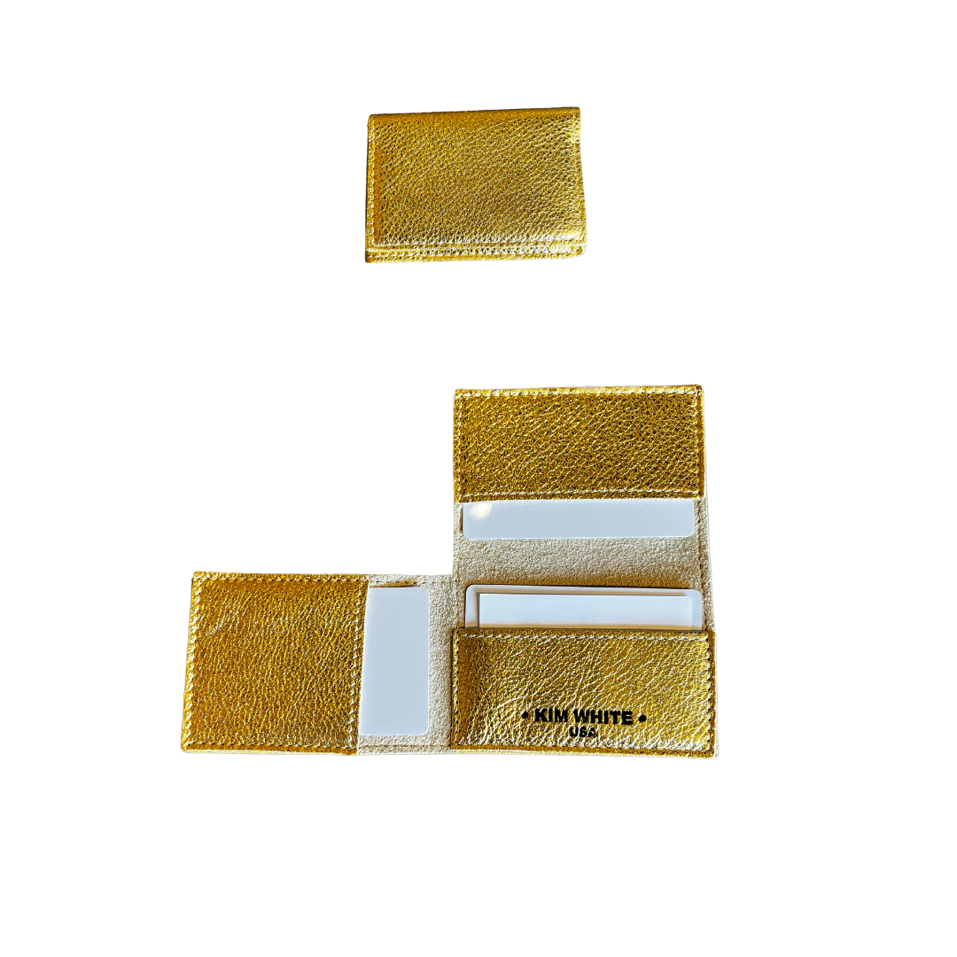 A gold foldover wallet made of leather, displayed both closed and open showing the interior compartments.